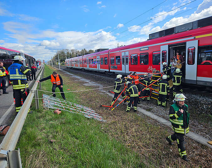 Feuerwehrkräfte helfen Fahrgästen aus dem Zug